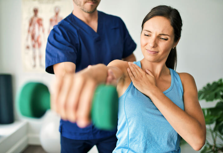 Male Physical Therapist Stretching a Female Patient Slowly